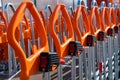 Shopping trolleys with orange handles lined up at hardware store