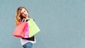 Shopping woman holding color shopping bags. Girl posing over grey background, copy space. Female beauty and fashion concept. Royalty Free Stock Photo