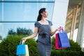 Shopping. Woman holding colored bags near her shooping mall in black friday holiday Royalty Free Stock Photo