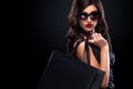 Shopping woman holding grey bag isolated on dark background in black friday holiday