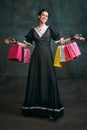 Shopping. Young beautiful woman in image of Anna Karenina in retro black dress posing over dark vintage background Royalty Free Stock Photo