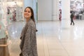 Shopping A young girl looks at shop windows, smiles, makes purchases in a mall Royalty Free Stock Photo