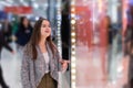 Shopping A young girl looks at shop windows, smiles, makes purchases in a mall Royalty Free Stock Photo