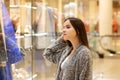 Shopping A young girl looks at shop windows, smiles, makes purchases in a mall Royalty Free Stock Photo