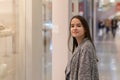 Shopping A young girl looks at shop windows, smiles, makes purchases in a mall Royalty Free Stock Photo