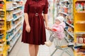 Shopping. A young woman rolls a grocery cart in a supermarket, in which her baby is sitting. Close-up of the baby Royalty Free Stock Photo