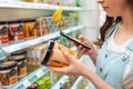 Shopping. Young woman scans the composition of the body cream. Modern technology in everyday life. Close up