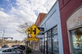 Shops, restaurants, a coffee shop and various businesses along Veterans Memorial Hwy with parked cars, a red brick sidewalk