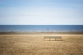 Shore of Baltic sea with a bench on empty beach. Royalty Free Stock Photo