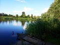 The shore of a blue lake with a wooden bridge. Rustic style