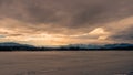 On the shore of the frozen lake Kirchsee with ice sheets in Upper Bavaria with Alps in background in winter with snow