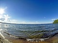 Shore of the lake, sand, lapping waves, blue sky with light clouds, fisheye lens, lake Uvildy