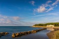 Shore line with sandy beach and rock wave breaker