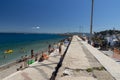 Shore with reef and small beach with bathers in porto santo stefano Royalty Free Stock Photo