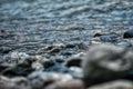 Shore of a river with stones and water with blur front view