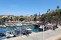 The shore of the tourist port. View of the Mediterranean Sea, ships and yachts. People walk along the shore. Antalya