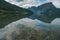 Shore of vang lake in Norway, beautiful summer landscape, mountains and clouds are reflected in the water Royalty Free Stock Photo