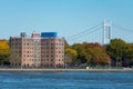 Shoreline of Astoria Queens New York with Public Housing Buildings and the East River with Colorful Autumn Trees and a Bridge in t