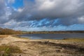 A shoreline at a lake with a dramatic sky in the background. Picture from Lake Vomb, Scania, Sweden Royalty Free Stock Photo