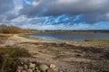 A shoreline at a lake with a dramatic sky in the background. Picture from Lake Vomb, Scania, Sweden Royalty Free Stock Photo