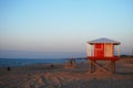 Red lifeguard station waits silently on a deserted beach