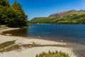 Shoreline of a picturesque lake and mountains on a hot summers day (Buttermere, Lake District Royalty Free Stock Photo