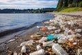 shoreline teeming with plastic bottles, caps, straws Royalty Free Stock Photo