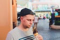 Short bearded man eating ice cream cone in a town street. Royalty Free Stock Photo