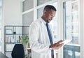 A short break from a busy day. a young doctor using a digital tablet in an office. Royalty Free Stock Photo