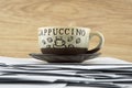 Short break for the hard worker: a Cup of hot coffee and a brown saucer on a disorderly stack of papers, the bottom view from the Royalty Free Stock Photo