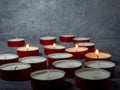 Short candles are burning against a dark background. Lots of small candles. Not all candles are lit Royalty Free Stock Photo