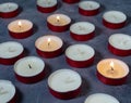 Short candles are burning against a dark background. Lots of small candles. Not all candles are lit Royalty Free Stock Photo