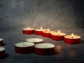 Short candles are burning on a dark surface. Lots of small candles. Not all candles are lit Royalty Free Stock Photo