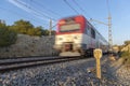 White and red short distance train in motion when leaving a tunnel and with a kilometric road sign Royalty Free Stock Photo