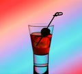 Short drink glass with red liquid and green olive Royalty Free Stock Photo