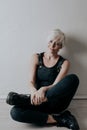 Short-haired blonde sits on the floor in the room Royalty Free Stock Photo