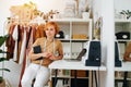 Short-haired seamstress posing next toher workdesk with a notebook Royalty Free Stock Photo