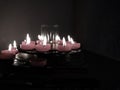 Short Lit Religious Candles In Dull Light