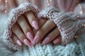 short nails with white and pink nail polish, winter themed, in a knitted sweater, closeup photo, soft light, pastel Royalty Free Stock Photo