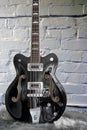 Short scale Gretsch bass guitar on white brick background