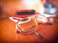 Short-sighted eyesight glasses with address book and phone in the background