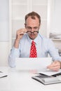 Short sighted at work - balding businessman looking through glasses at document - funny Royalty Free Stock Photo