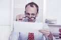 Short sighted at work - balding businessman looking through glasses at document Royalty Free Stock Photo