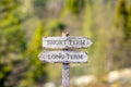 short term long term text carved on wooden signpost outdoors in nature. Royalty Free Stock Photo