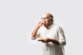 Indian old man eating phuchka, panipuri, gupchup or golgappa