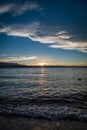 Waves crash on Lakeside Beach at Lake Tahoe during sunset with mountains splitting the middle of the picture