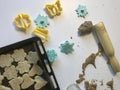 Shortbread cookie with sesame on a baking sheet. Before shipment to the oven. Nearby lie molds for shaping the dough and a wooden