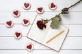 Shortbread homemade heart shaped cookies with empty notebook, pencil and rose flower on white wooden background for Royalty Free Stock Photo