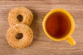 Shortbread rings with peanut, cup of tea on wooden table. Top view