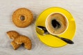 Shortbread rings with sesame, broken cookie, cup of espresso, spoon on saucer on table. Top view Royalty Free Stock Photo